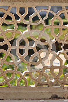 Intricate stone fence looking through to Amber Fort Gardens Jaipur India