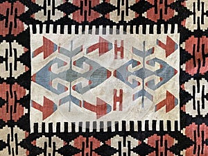 Intricate tribal-patterned Turkish rug with geometric shapes and traditional handwoven design, featuring a rich blend of colors