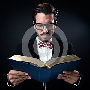 Intrigued businessman with glasses reading a book. Isolated on b photo