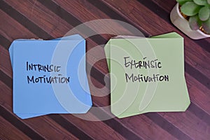 Intrinsic Motivation and Extrinsic Motivation write on sticky notes isolated on Wooden Table