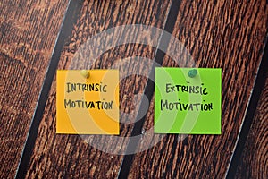 Intrinsic Motivation and Extrinsic Motivation write on sticky notes isolated on office desk