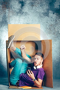 Introvert concept. Man sitting inside box