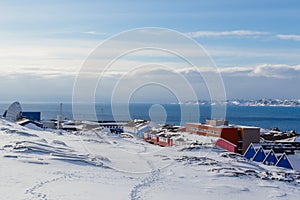 Inuit village houses covered in snow at the fjord of Nuuk city, Greenland