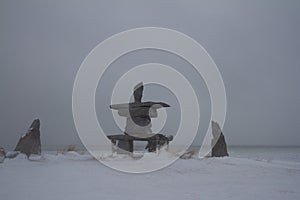 Inukshuk or Inuksuk with snow on the ground in early November found near Churchill, Manitoba