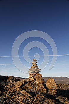 Inukshuk or Inuksuk at the top of the mountain along a hiking trail near the community of Qikiqtarjuaq