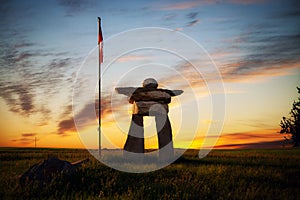 An Inukshuk in a prairie sunset