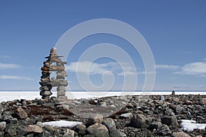 Inuksuk landmark with frozen bay in the background