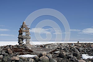 Inuksuk landmark with frozen bay in the background photo