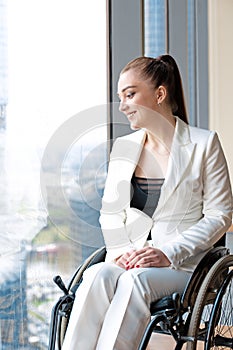 Invalid or disabled young business woman person sitting wheelchair in office