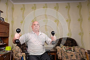 Invalid old man doing exercises with dumbbells