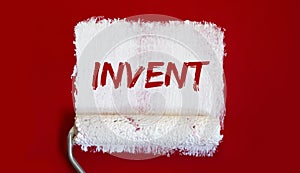 INVENT .One open can of paint with white brush on red background. Top view