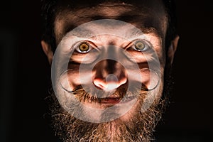 Inventor Hipster with Beard and Mustages in the Dark Room. Smiling Trickster. photo