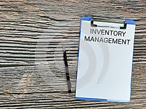 Inventory management written on paper clipboard with a pen.