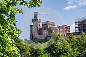 Inverness Castle with construction area next to it and trees in front, Scotland