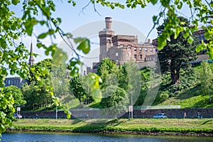 Inverness Castle with tree leaves and river in front, Scotland