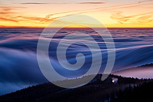 Inversion almost above the ski resort with lift and snow cannon