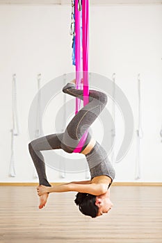 Inversion pigeon pose in aero anti gravity yoga. Aerial exercises