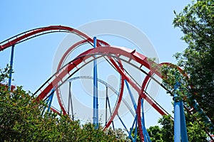 Inverted roller coaster with narrow metal rails, an ideal summer day to enjoy vacations