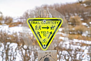 Inverted triangle Trail Courtesy Yield To sign with graphics and arrows