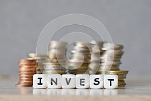 Invest and a coin on wooden table background, invest business economy concept of money and finance investments