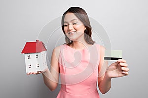 Invest in real estate concept. Woman holding small toy house and