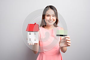 Invest in real estate concept. Woman holding small toy house and
