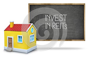 Invest in reits text on blackboard with 3d house