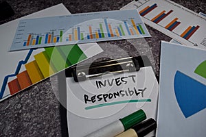 Invest Responsibly write on clipboard isolated on Office Desk. Stock market concept