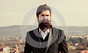 Invest in stylish appearance. Grow thick beard fast. Man bearded hipster wear formal suit blue sky background. Vintage