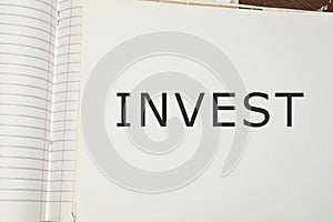 invest word written on white paper