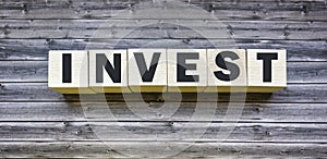 invest word written on wooden block