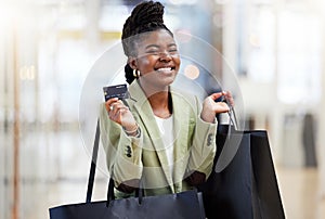 Invest in your financial future. a young woman using her bank card to pay for a day of fun shopping.