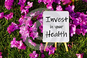 Invest in your health. On background of pink flowers and green grass.