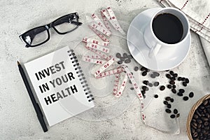 INVEST IN YOUR HEALTH text written on a notebook.