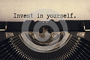 Invest in yourself text typed on an old vintage typewriter in black and white