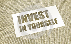 Invest in Yourself words on card on burlap canvas. Business education concept