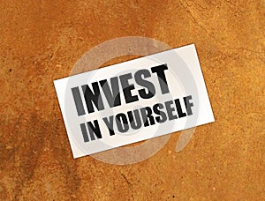 Invest in Yourself words on card on wooden table. Business education concept