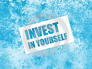 Invest in Yourself words on card on wooden table. Business education concept