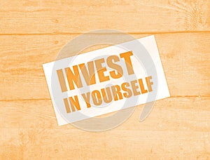 Invest in Yourself words on card on wooden table. Business education concept