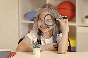 investigate with loupe. science and childhood. teen girl looking at plant through magnifier