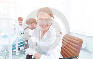 Investigator checking test tubes, Woman wears protective goggles