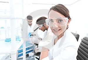 Investigator checking test tubes, Woman wears protective goggles