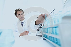 Chemist looking at test-tubes with blue liquids