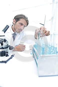 Chemist looking at test-tubes with blue liquids