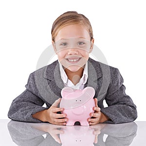 Investing in her future....Studio portrait of a young girl dressed like a businesswoman holding a piggybank.