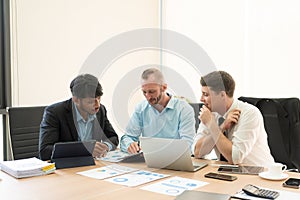 Investment advisor meeting of three businessmen analyzing company financial report,