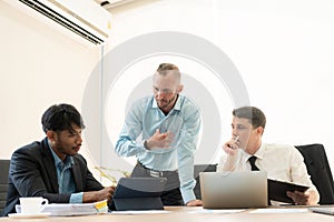 Investment advisor meeting of three businessmen analyzing company financial report,