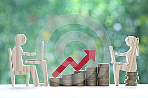 Investment and business concept,Man and woman using laptop computer with stack of coin money and red arrow graph on natural green
