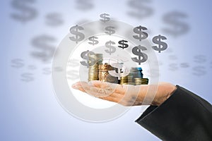 Investment concept, close up of male hand holding a stack of golden coins and virtual dollar sign isolated on white background