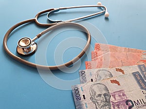 investment in health care, Costa Rican money and stethoscope for medical check